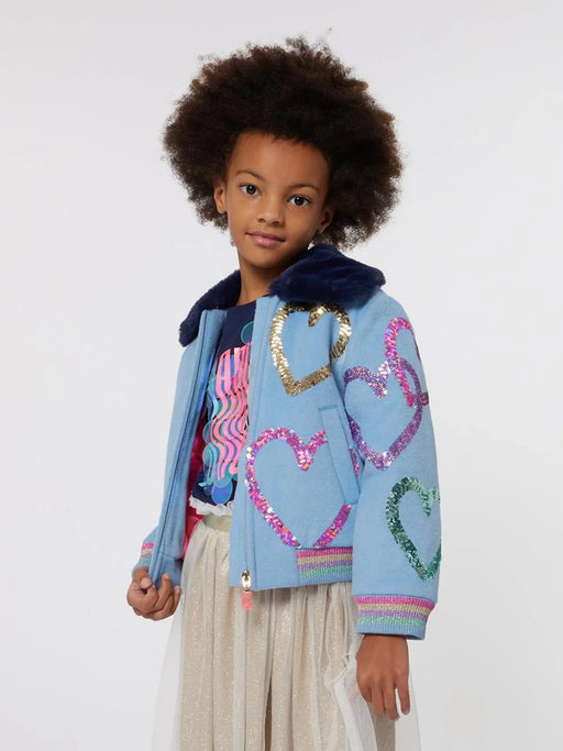 Girl wearing the Billieblush sequin heart jacket.