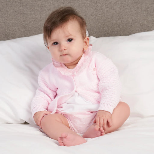 Baby girl wearing the Dandelion Matinee Cardigan.