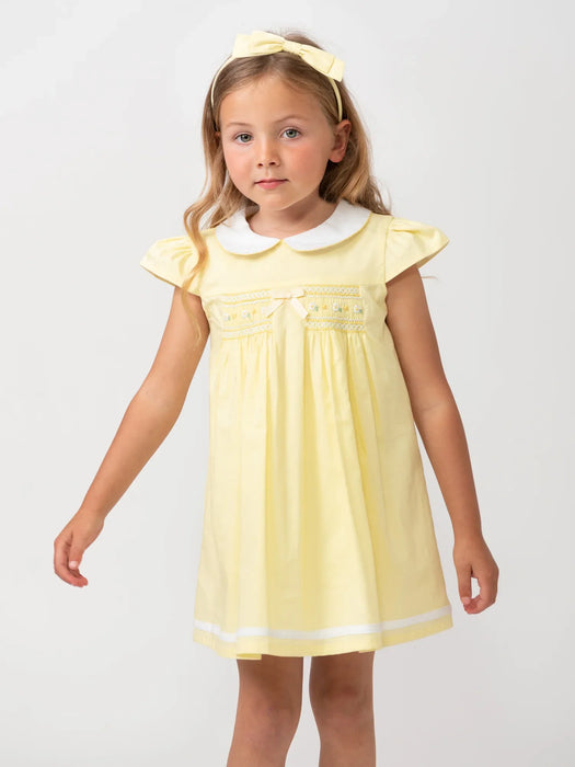 Girl wearing the Caramelo smocked dress.