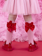 A Dee lucy knee socks with red bows on the back.