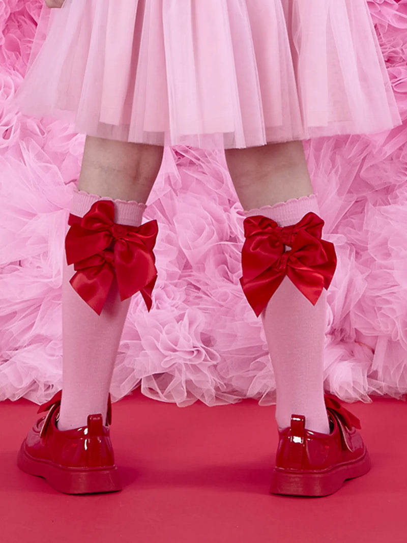 A Dee lucy knee socks with red bows on the back.