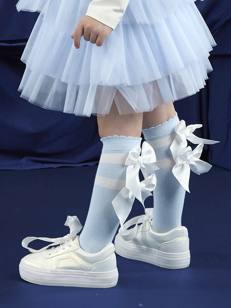 A Dee meave knee socks with white bows on the back.
