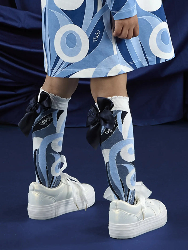 A Dee nieve knee socks with navy bows on the back.