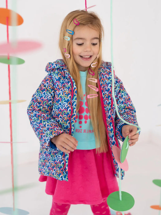 Smiling girl modelling the Agatha Ruiz de la Prada heart print coat.