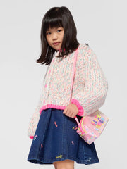 Girl in white chunky knit cardigan by Billieblush.