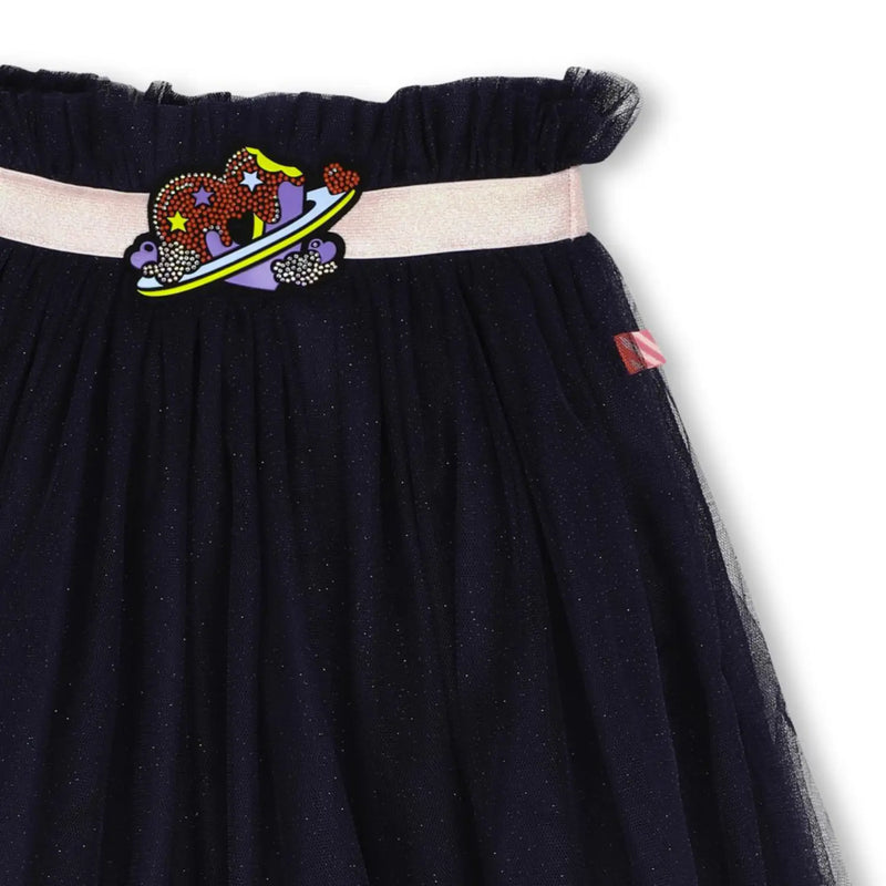 Closer look at the Billieblush tulle skirt showing detail of the purple heart logo.