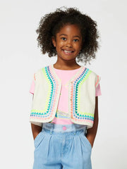 Smiling girl modelling the Billieblush sleeveless jacket.