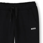 Closer look at the boy's black track bottoms.