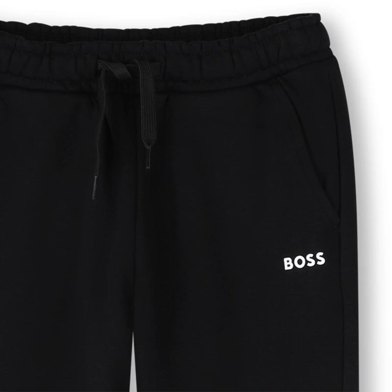 Closer look at the boy's black track bottoms.