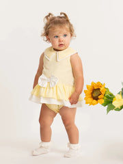 Baby girl wearing the Caramelo bow dress.