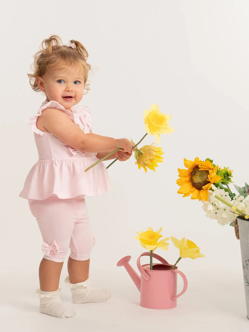 Smiling baby girl modelling the Caramelo bow leggings set.