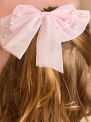 Girl modelling the Caramelo pearl hair bow.