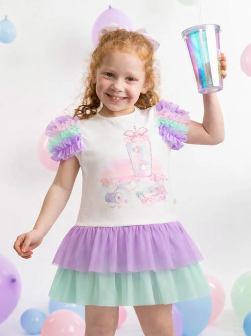 Girl wearing the Caramelo rainbow dress.