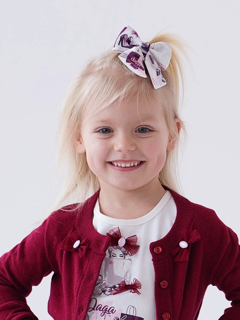 Smiling Girl modelling the Daga hair bow.