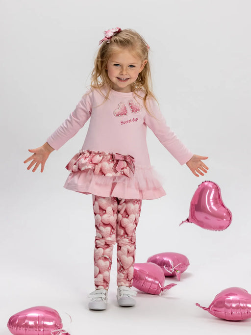Girl in pink heart print leggings set by Daga.
