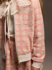 Closer look at the Daga tweed jacket showing detail of the embroidered crest design.