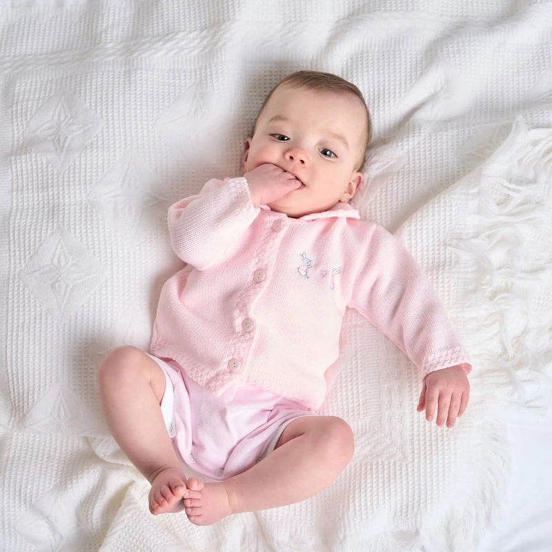 Baby girl wearing the Dandelion bunny cardigan.