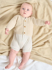 Baby wearing the Dandelion rib knit cardigan.
