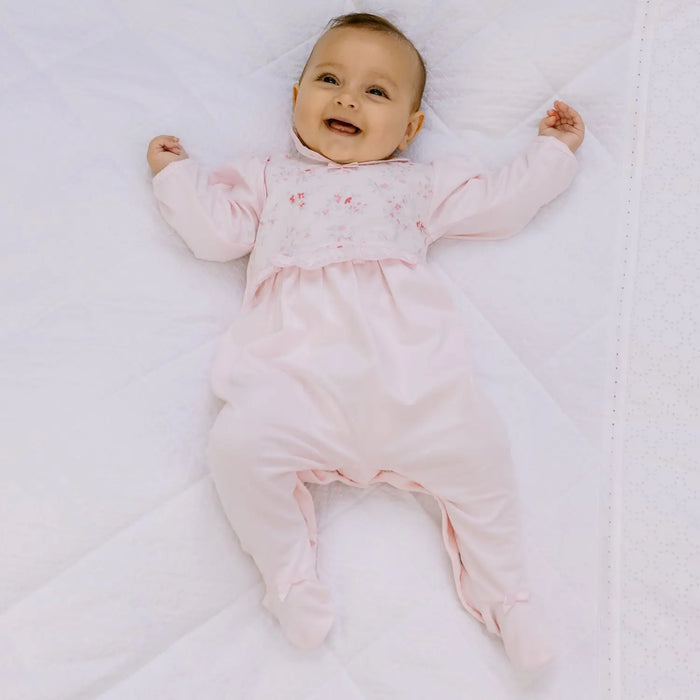 Smiling girl modelling the Emile et Rose fleur babygrow.