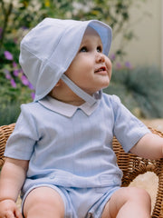 Smiling baby boy modelling the Emile et Rose gibson sun hat.