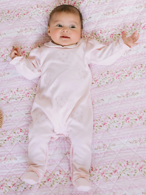 Smiling baby girl modelling the Emile et Rose jenna babygrow.