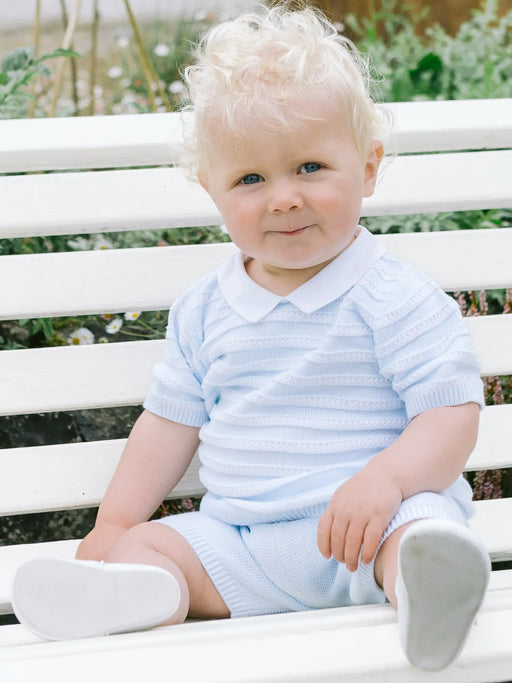 Smiling baby boy modelling the Emile et Rose jerry knitted shorts set.