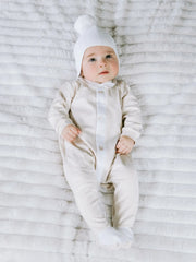 Baby in white kenton bobble hat by Emile et Rose.