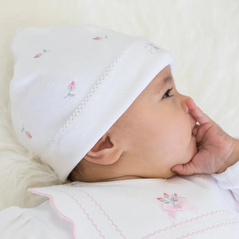 Baby girl wearing the Emile et Rose white embroidered hat.