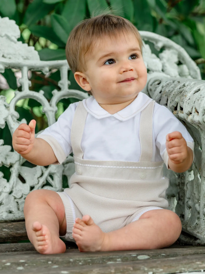 Smiling baby boy modelling the Emile et Rose lowe romper.