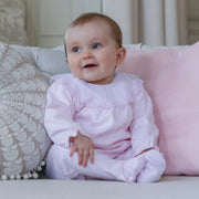 Smiling baby girl modelling the Emile et Rose mabel babygrow.