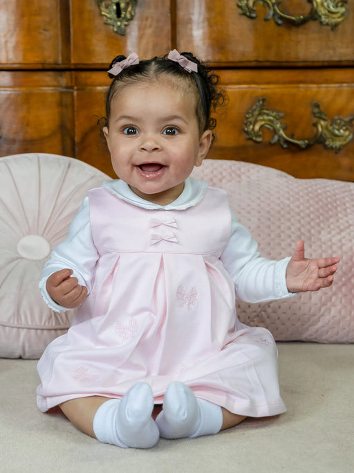 Smiling baby girl modelling the Emile et Rose mitzi dress.