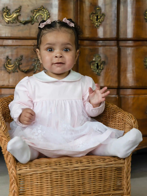 Smiling baby girl modelling the Emile et Rose molly dress.