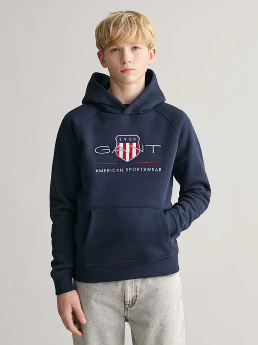 Boy modelling the GANT archive shield hoodie.
