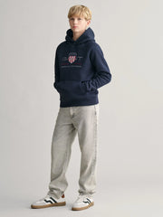 Boy modelling the GANT archive shield hoodie.