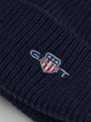 Closer look at the GANT shield beanie showing detail of the embroidered logo.