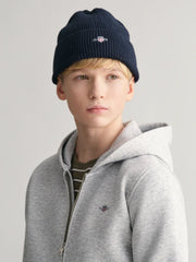 Boy modelling the GANT shield beanie.