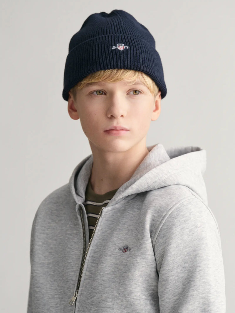 Boy modelling the GANT shield beanie.