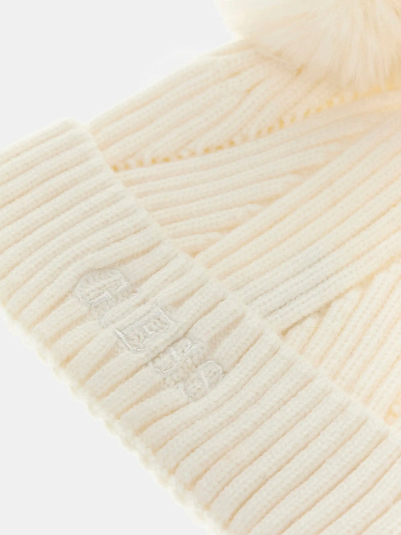Closer look at the Guess bobble hat showing detail of the embroidered logo.