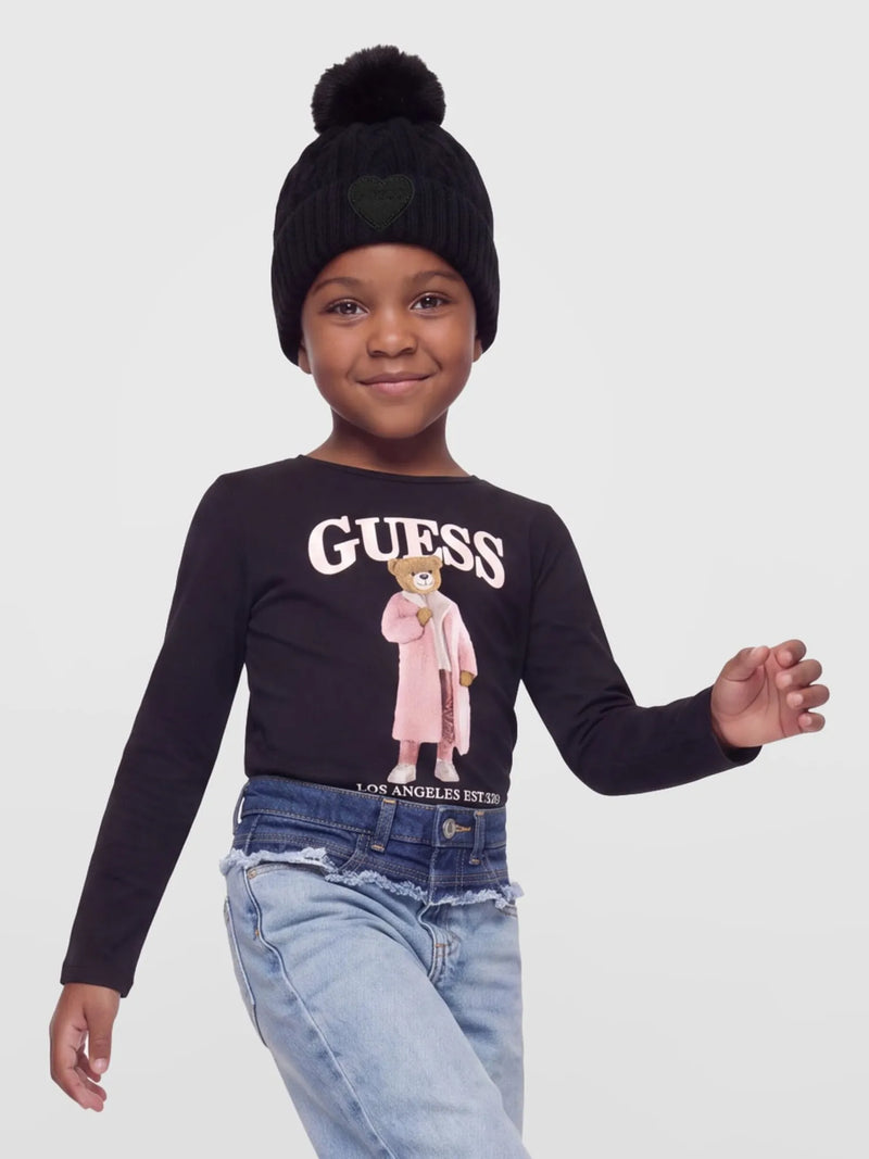 Smiling Girl modelling the Guess cable knit bobble hat.
