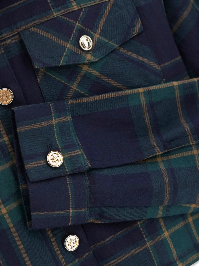Closer look at the Guess plaid shirt showing detail of the gold logo buttons.
