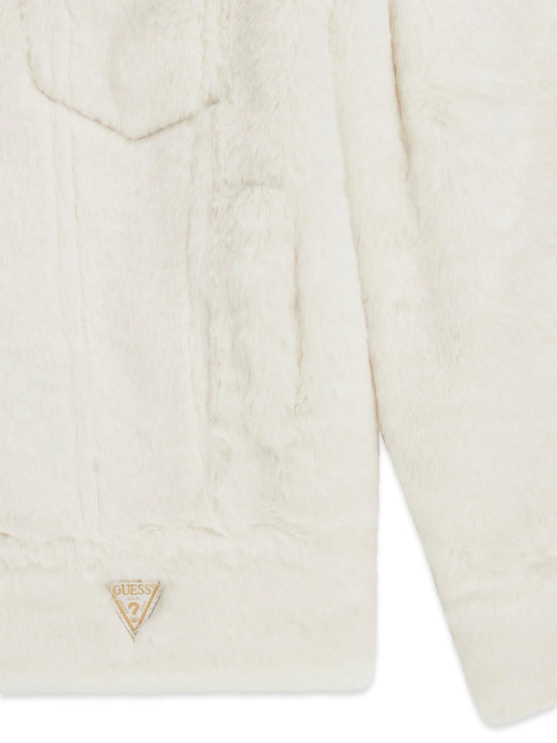 Closer look at the Guess faux fur jacket showing detail of the triangle logo patch at the hem.