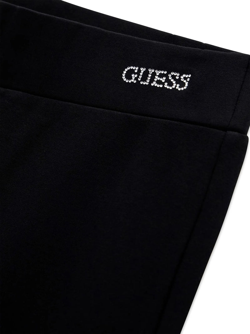 Closer look at the Guess flared leggings showing detail of the rhinestone logo at the hip.