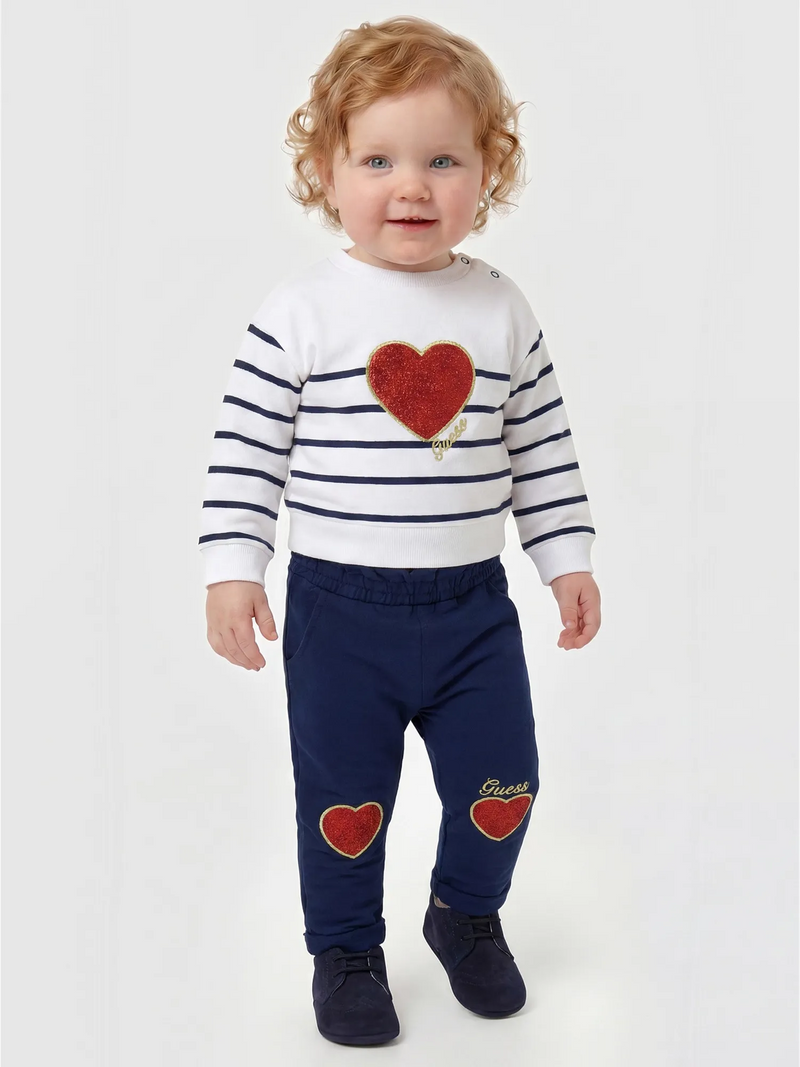 Baby girl wearing the Guess glitter heart tracksuit.