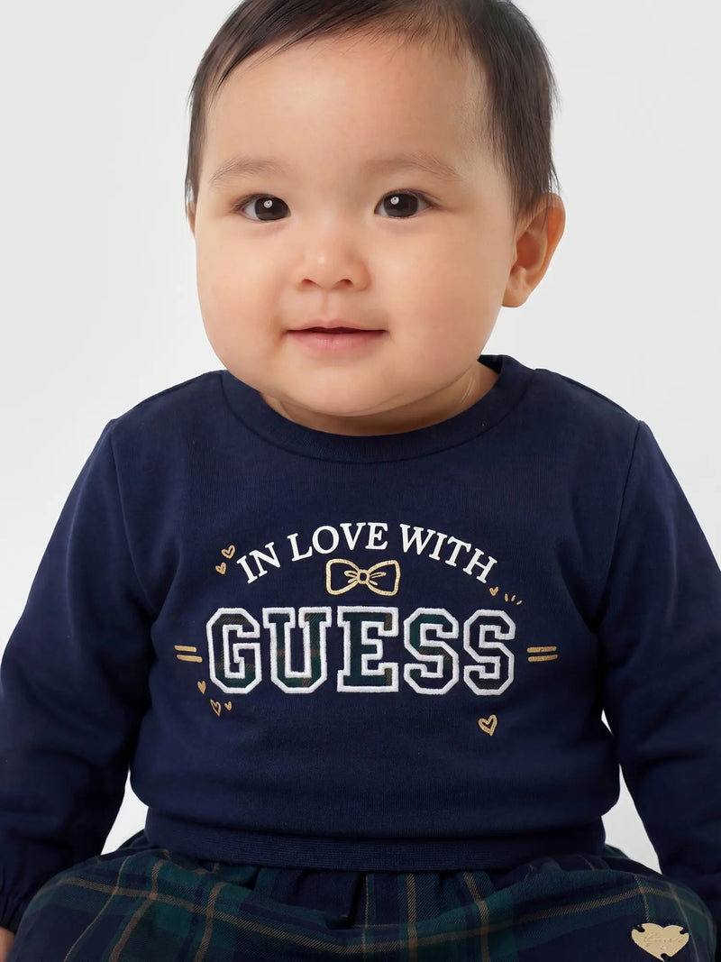 Baby girl wearing the Guess plaid skirt set.