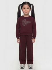 Girl wearing the Guess rhinestone logo tracksuit.