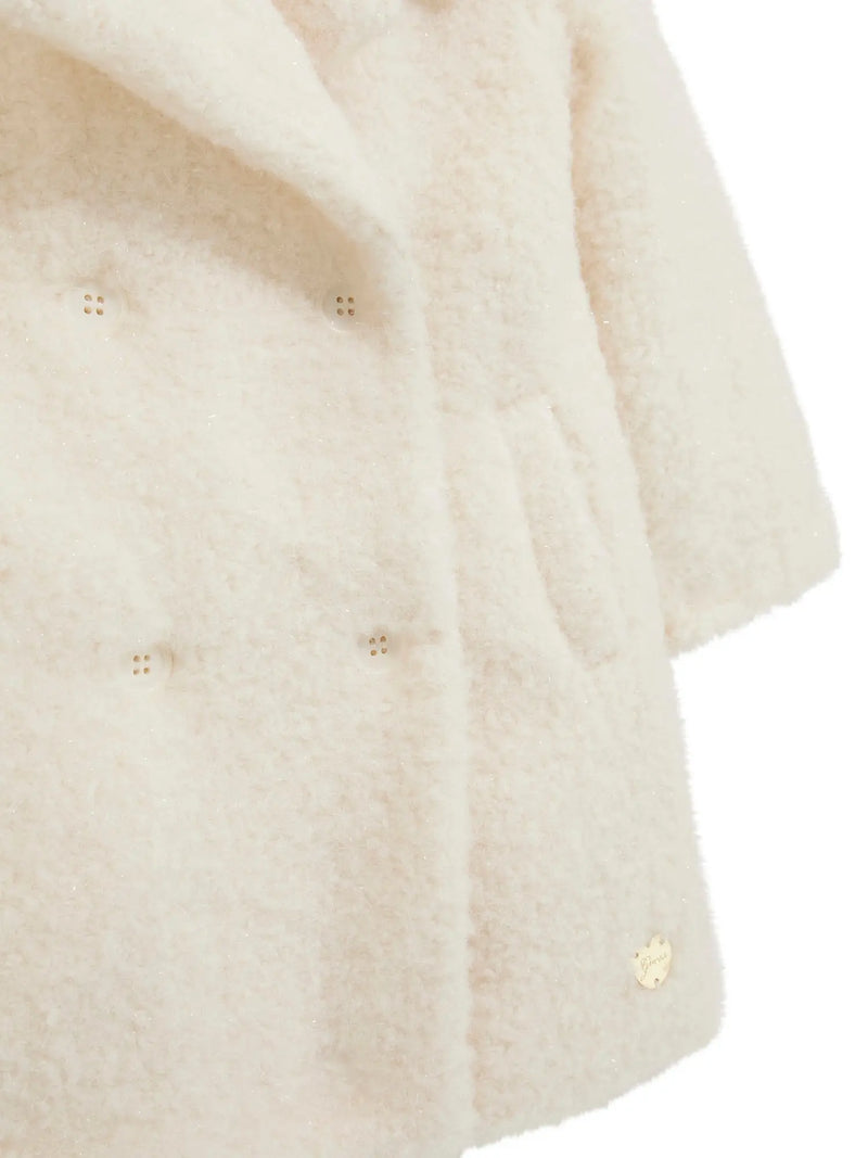 Closer look at the Guess sherpa button coat showing detail of the gold logo badge.