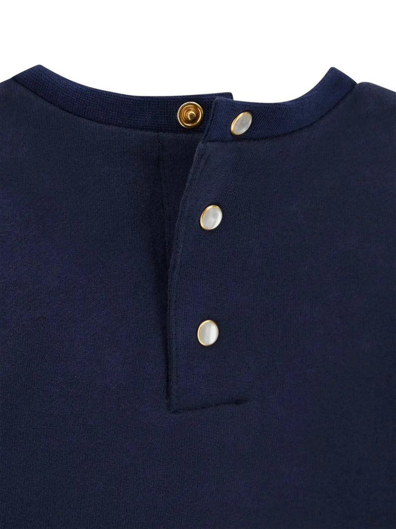 Closer look at the Guess navy top showing detail of the pearlescent button fasteners.