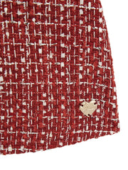 Closer look at the Guess tweed dress showing detail of the gold logo badge.