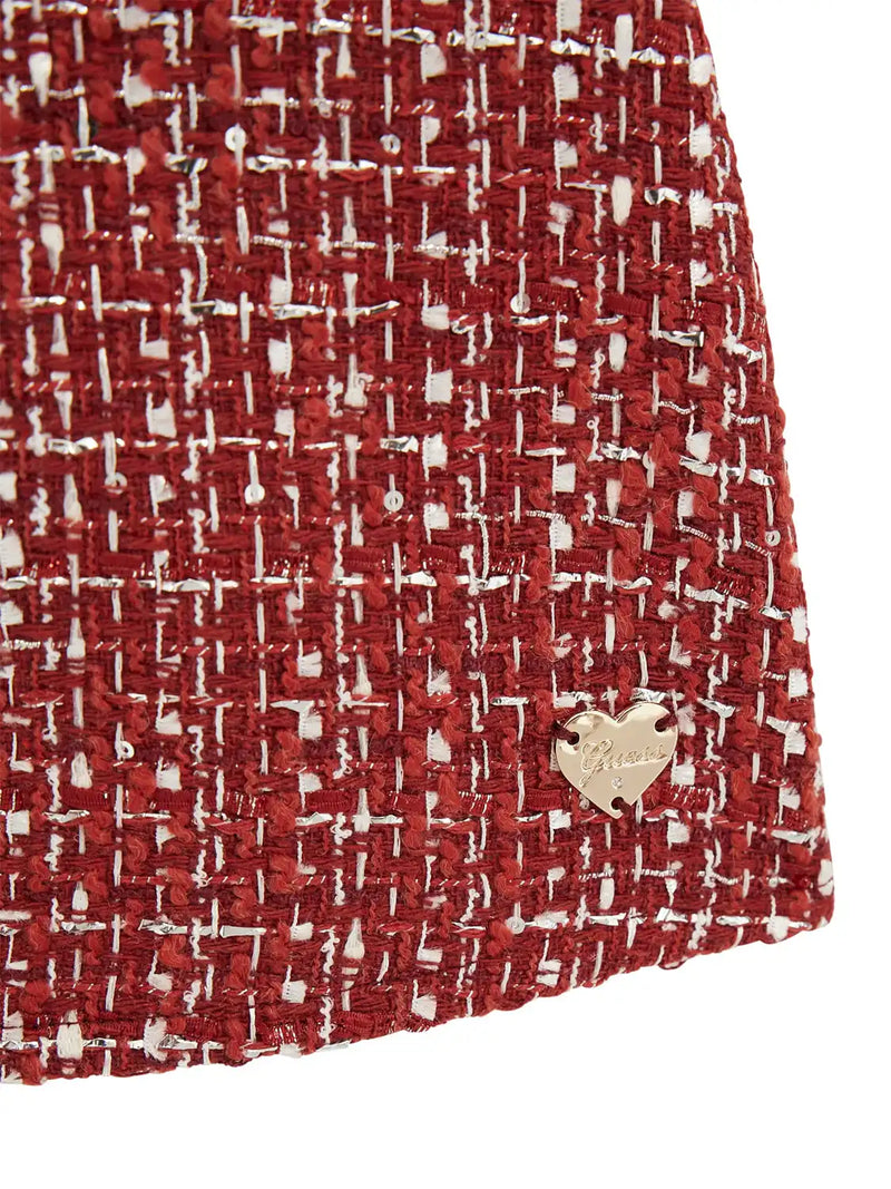 Closer look at the Guess tweed dress showing detail of the gold logo badge.