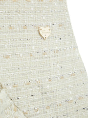 Closer look at the Guess tweed dress showing detail of the gold logo badge.